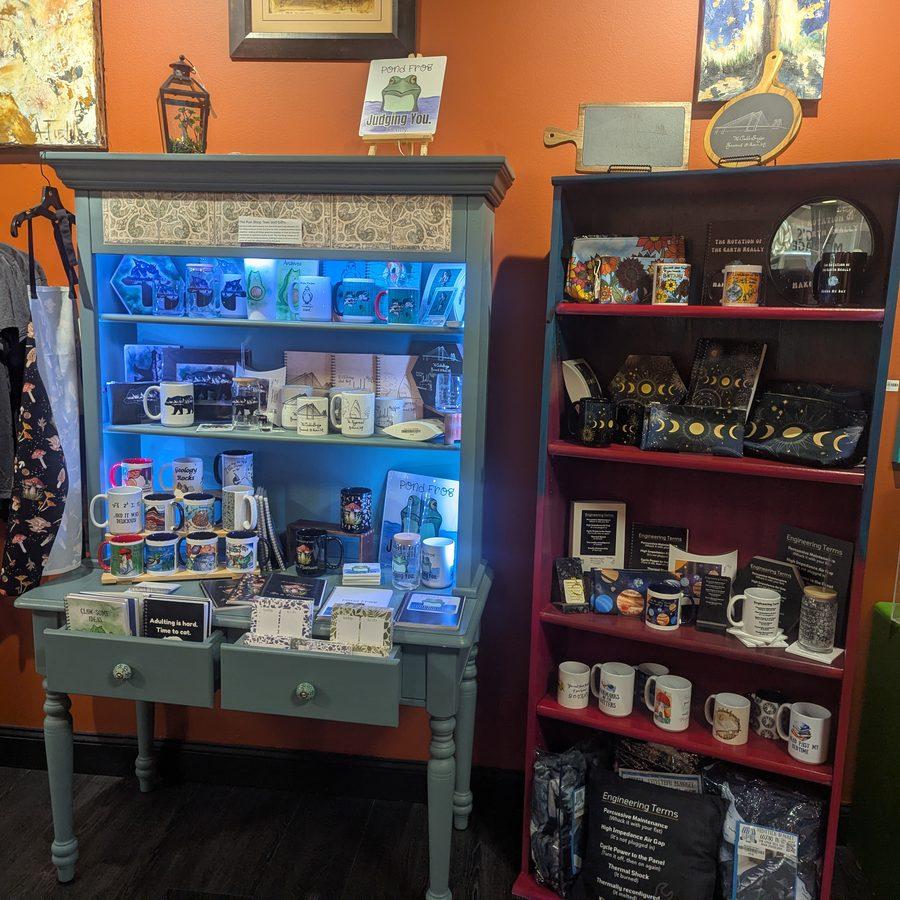 Blue-lit display cabinet of artisan mugs and moon-phase accessories
